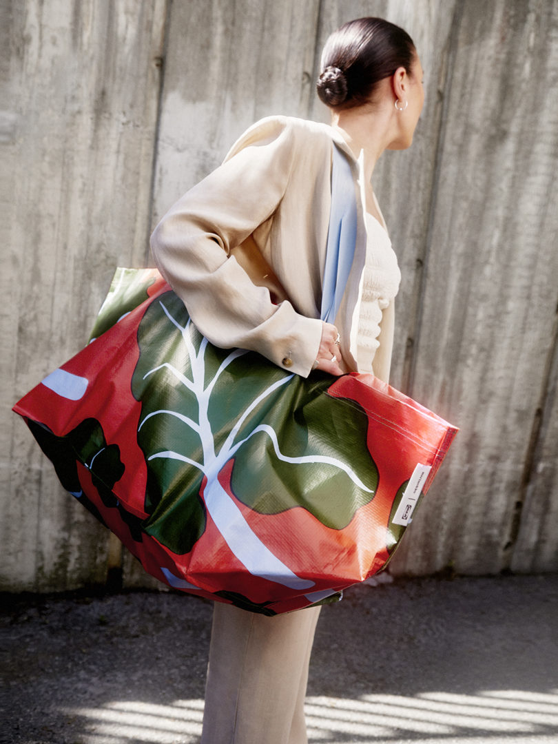 a person totes a large bag patterned with leaves