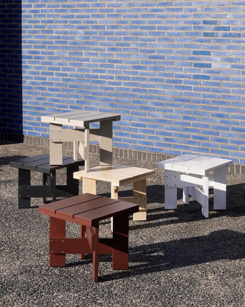 outdoor wood side tables in front of blue tiled wall