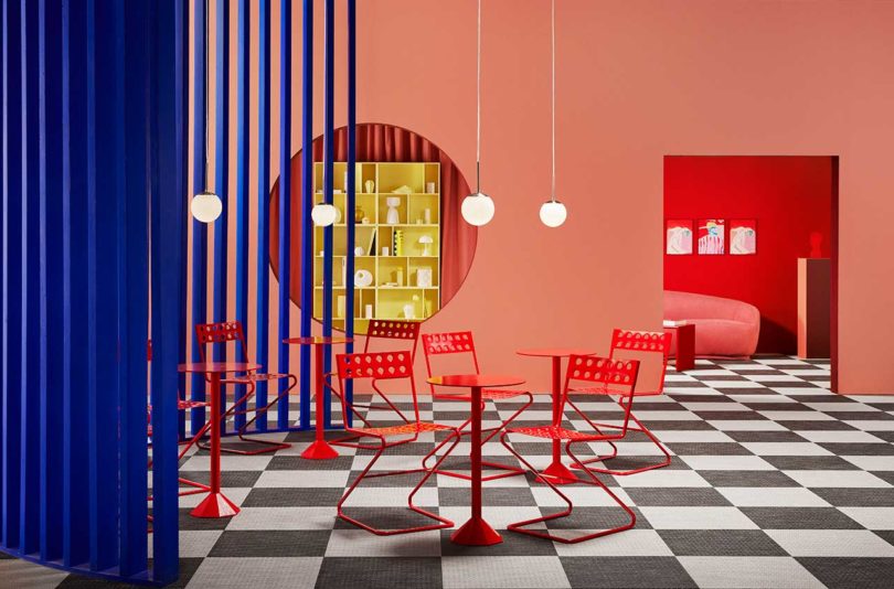 bold color-blocked exhibition space dining room with red table and chairs