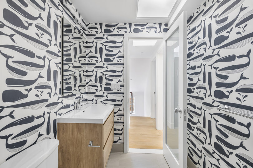 modern bathroom wallpapered in a whale pattern