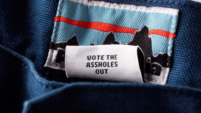 garment label that reads VOTE THE ASSHOLES OUT