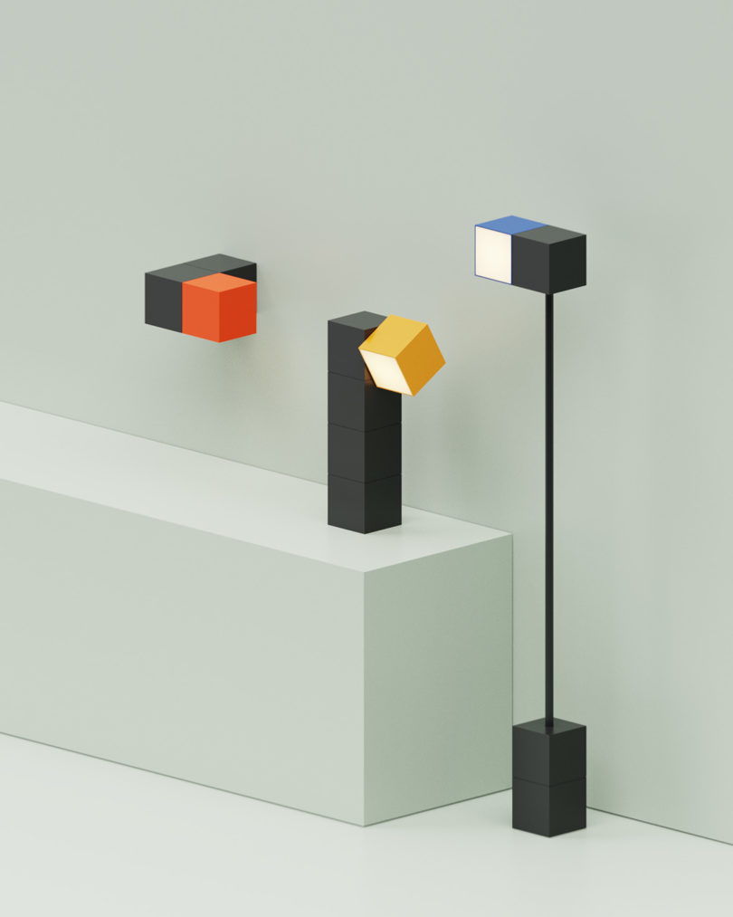 3D render of all three versions of the Analog lamp shown, including wall mounted, task/desk, and floor style staged in all white room, each with black base and colorful light heads.