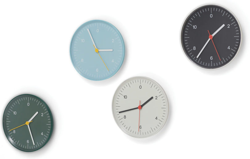 All four colors of HAY wall clock in green, light blue, white and black against all-white background.