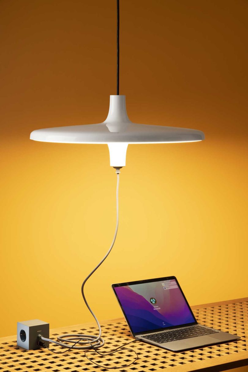 white pendant lamp powering a laptop