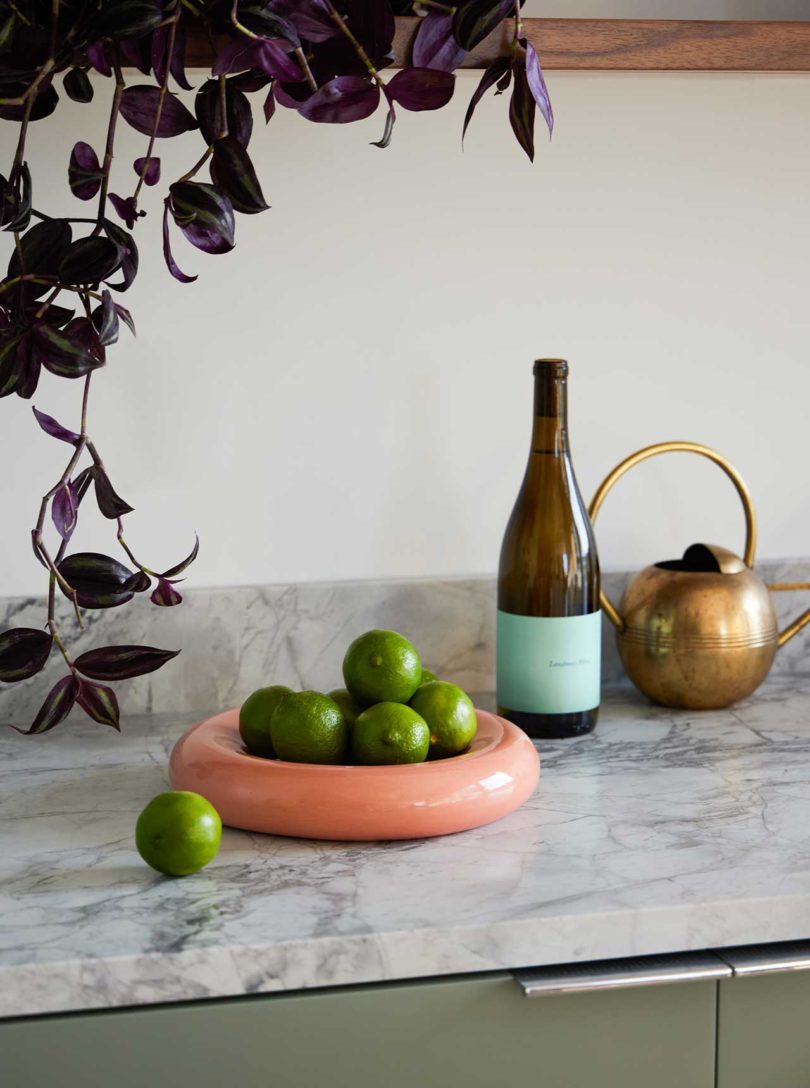 closeup counter view in modern kitchen with marble countertops and bowl of limes