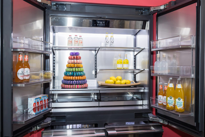 french door refrigerator opened up to reveal food an a tower of macarons inside