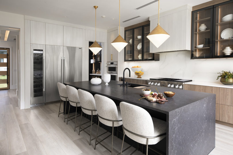 modern kitchen with island and stools and stainless appliances