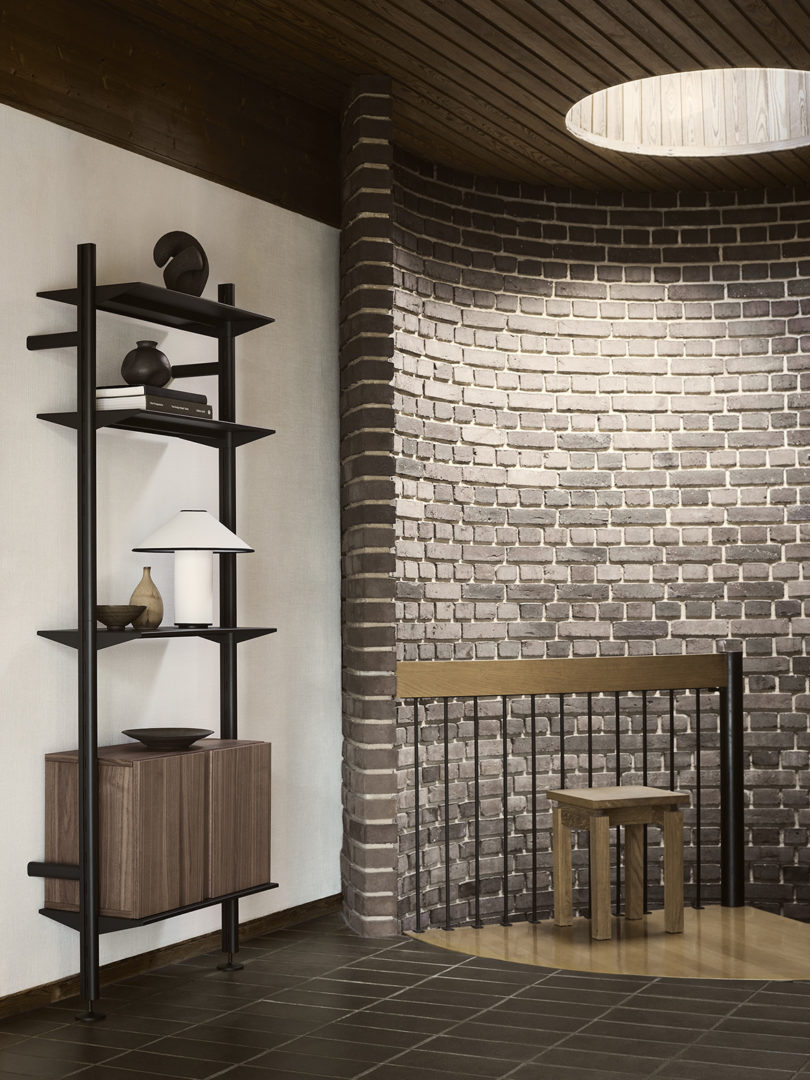 Black String Furniture shelving with dark wood veneer cabinet door set against wall near curved brick staircase.