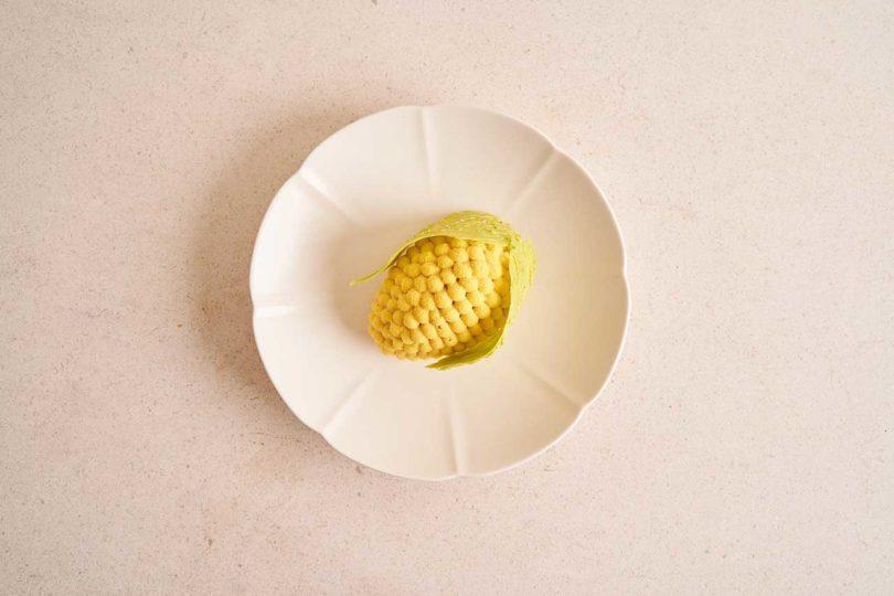 down view of a pastry resembling corn on a white plate