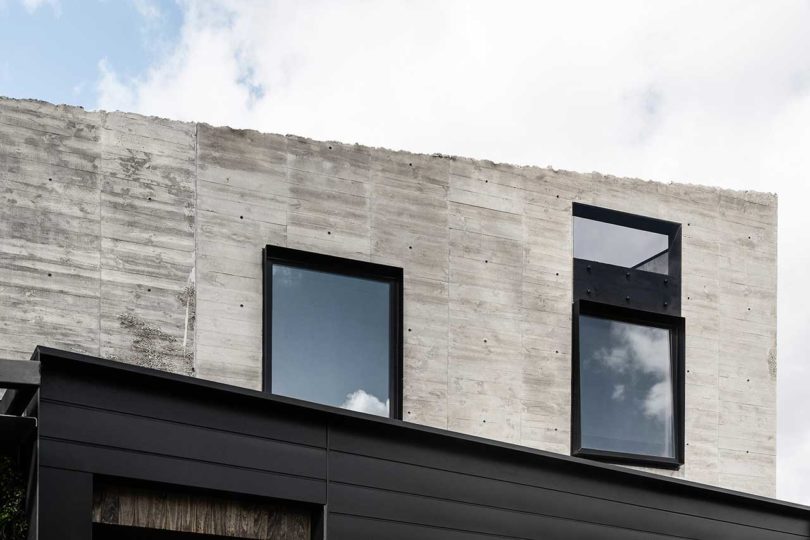 partial view of modern home exterior in concrete and black metal