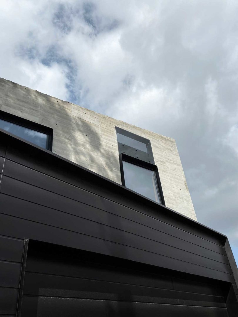 partial view of modern home exterior in concrete and black metal