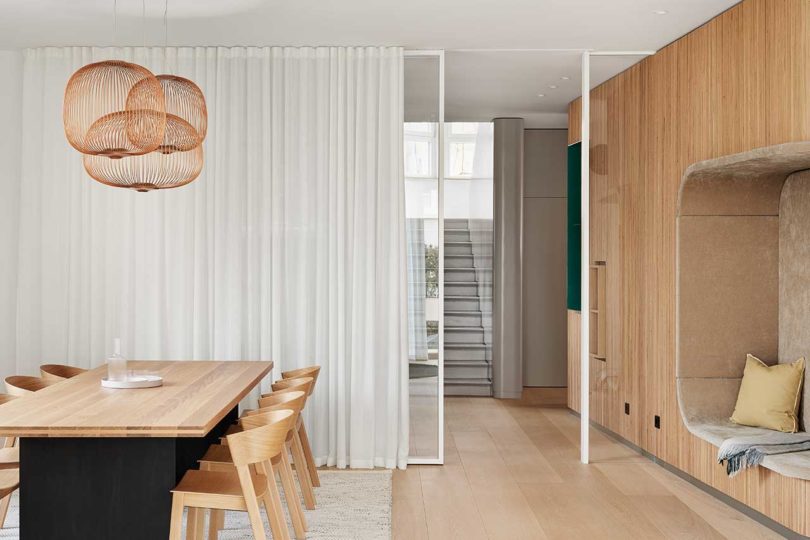 داخلی خانه مدرن با جزئیات چوبی و میز ناهار خوری با آویز سیم مسی
