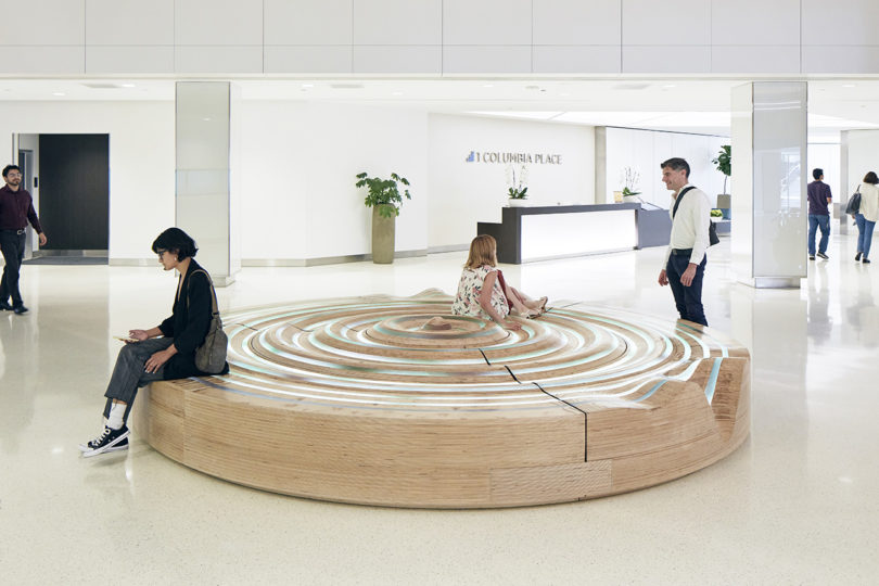 people interacting with a circular installation in a building's lobby