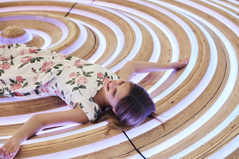 girl interacting with a circular installation in a building's lobby