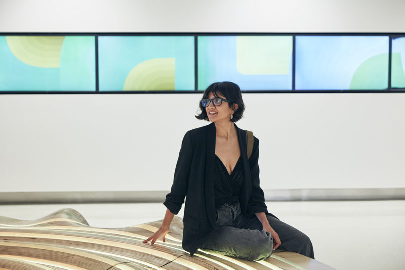 woman interacting with a circular installation in a building's lobby