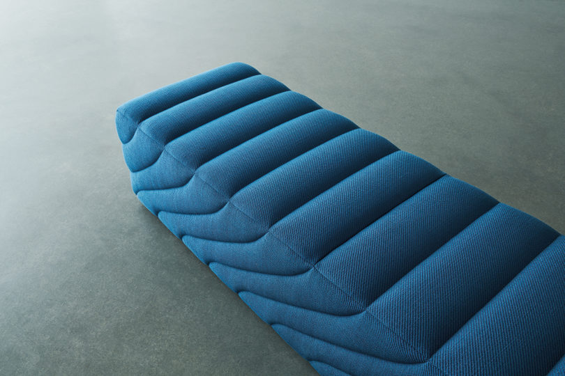 detail of blue upholstered straight bench on white background