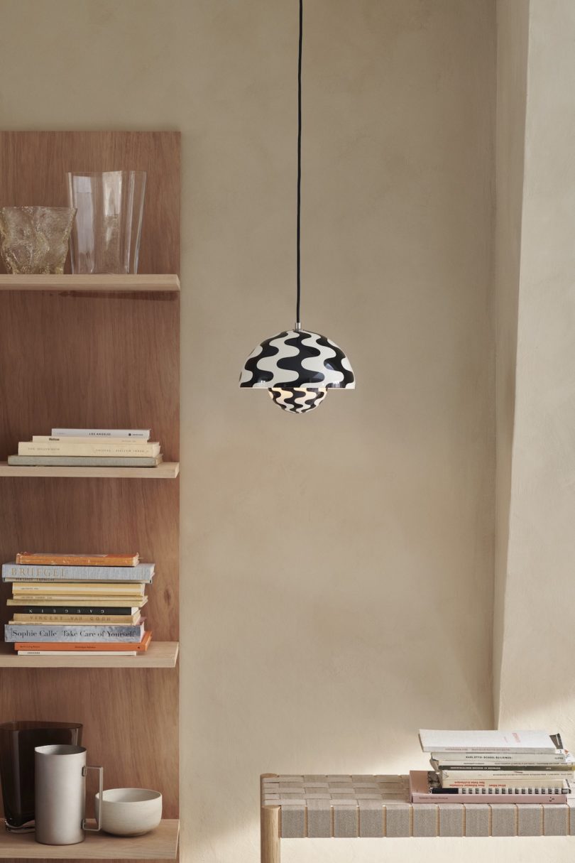 black and white wavy pendant light next to wall shelf