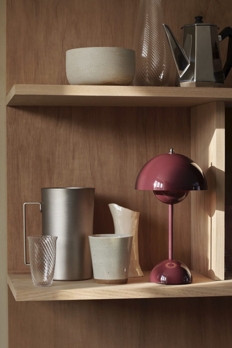 plum colored table lamp on wooden shelf