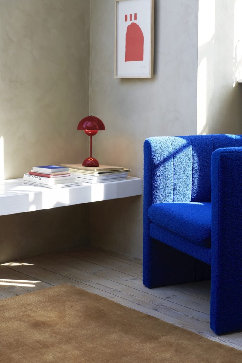 red table lamp next to blue armchair