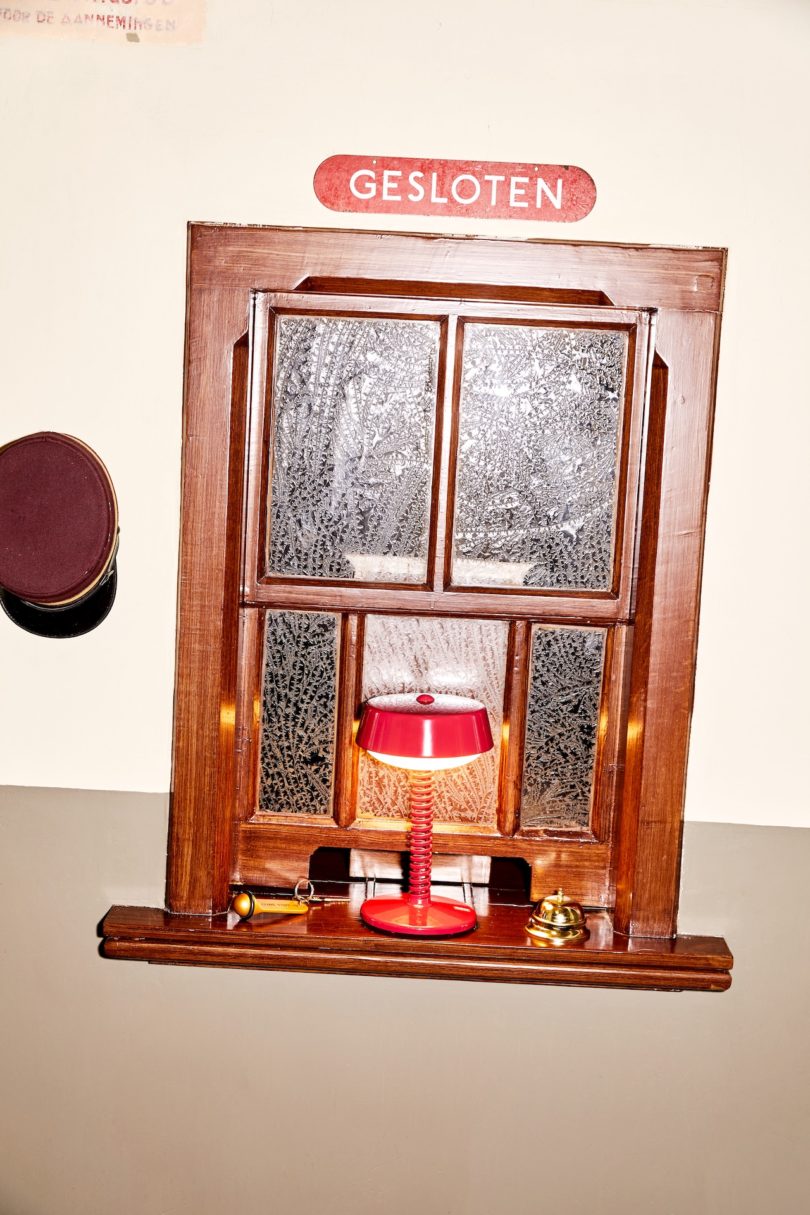 red table lamp on wooden window sill