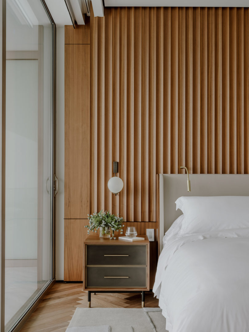 Bedroom with custom wood-paneled headboard
