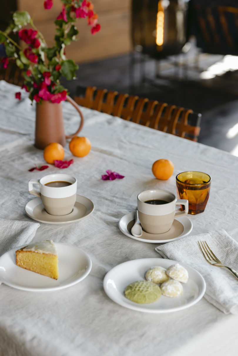 white and terracotta coffee mugs on table with breakfast spread