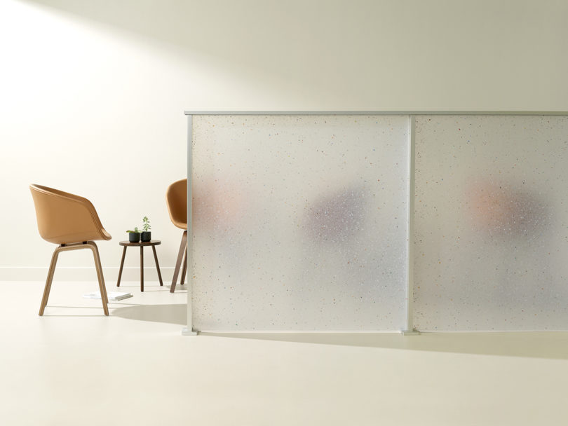 white semi-translucent panel in front of brown armchairs and side table
