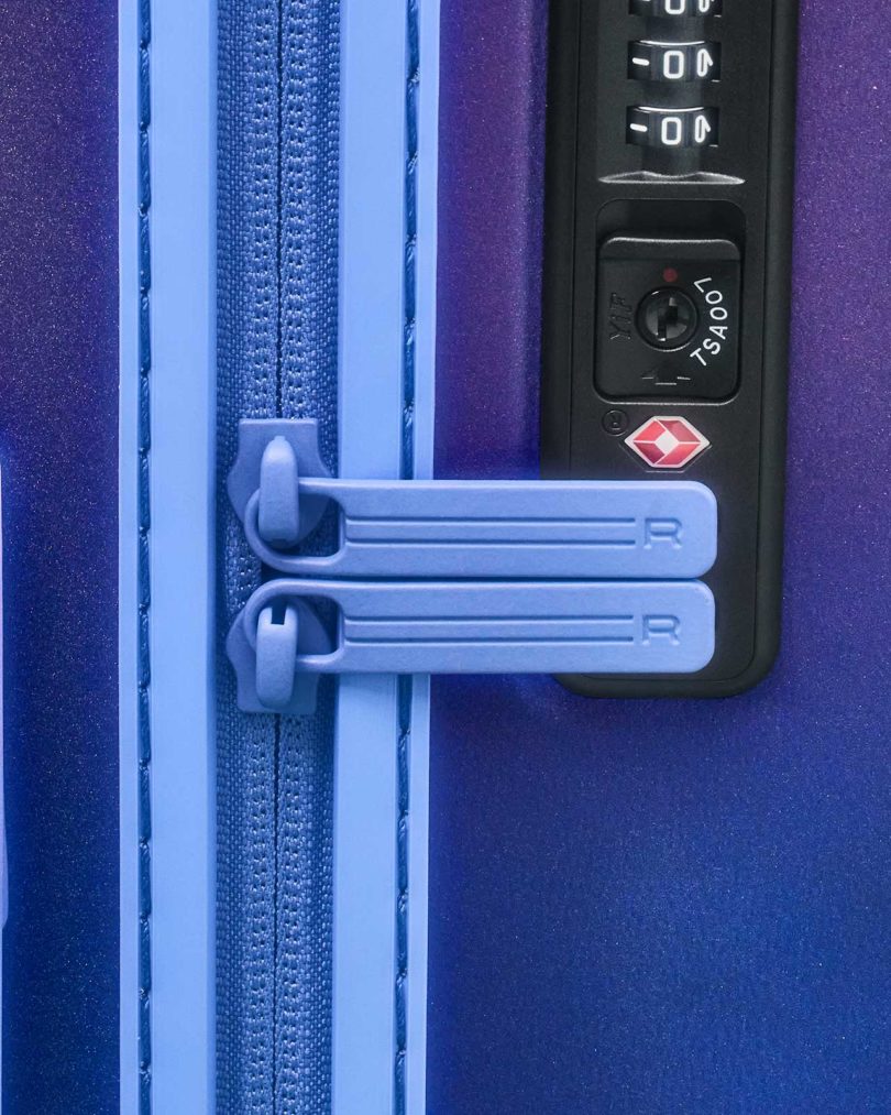 closeup of zippers and lock of blue suitcase