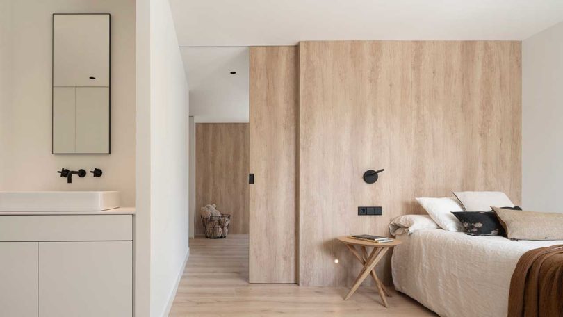 modern bedroom with sliding wood door opening up to another room