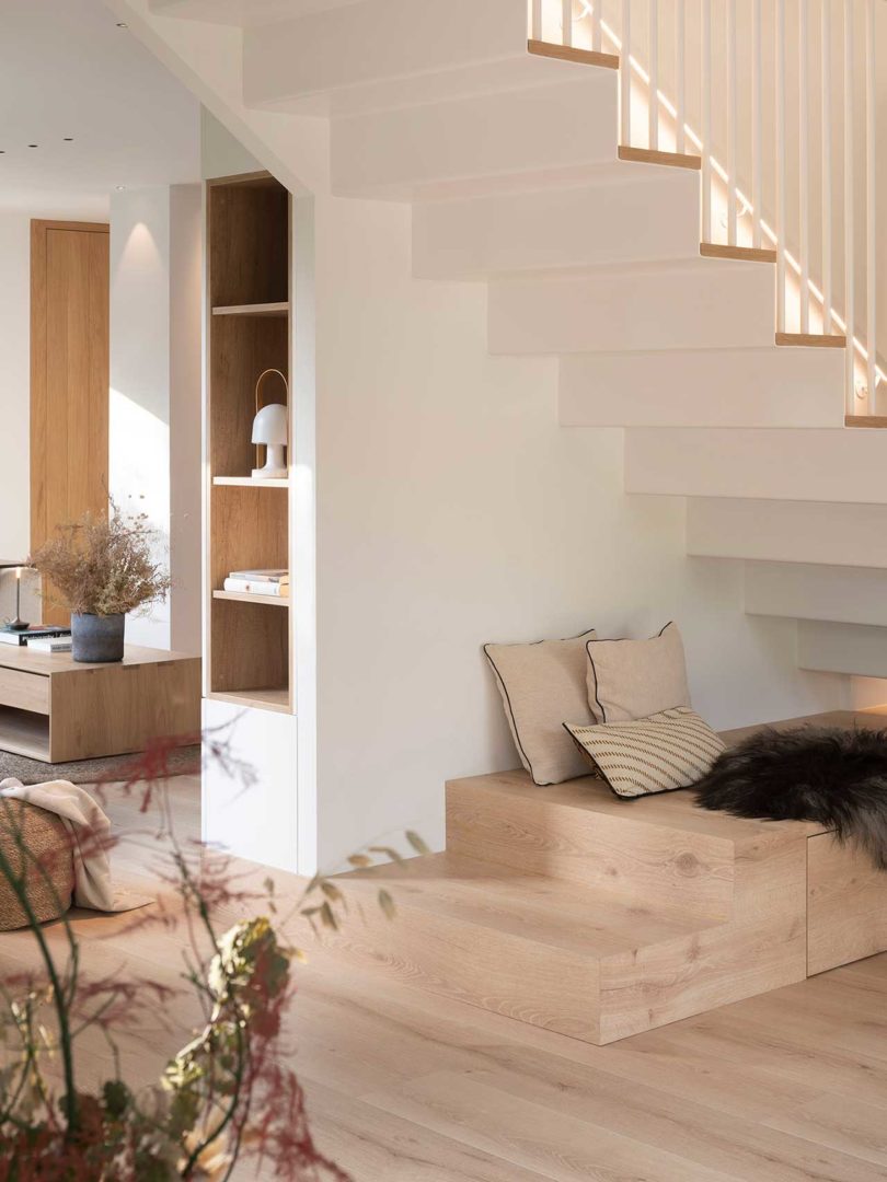 interior shot of light, white and wood modern home with view under stairs