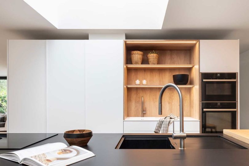 modern kitchen interior with black island countertop and white and wood cabinets