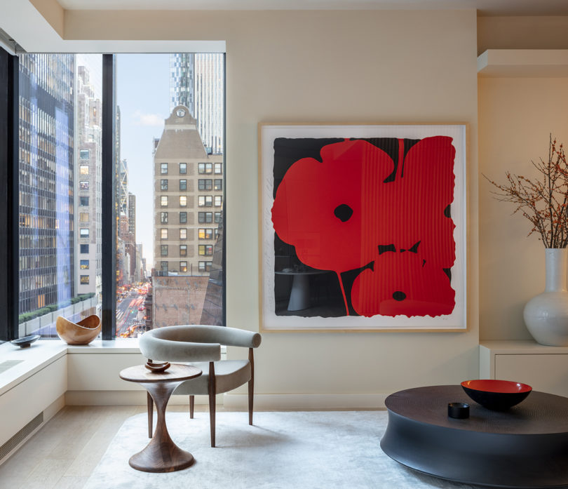 styled interior space with large red flower art and view of skyscrapers