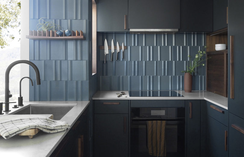 kitchen with dark cabinetry and vertical blue glass backsplash
