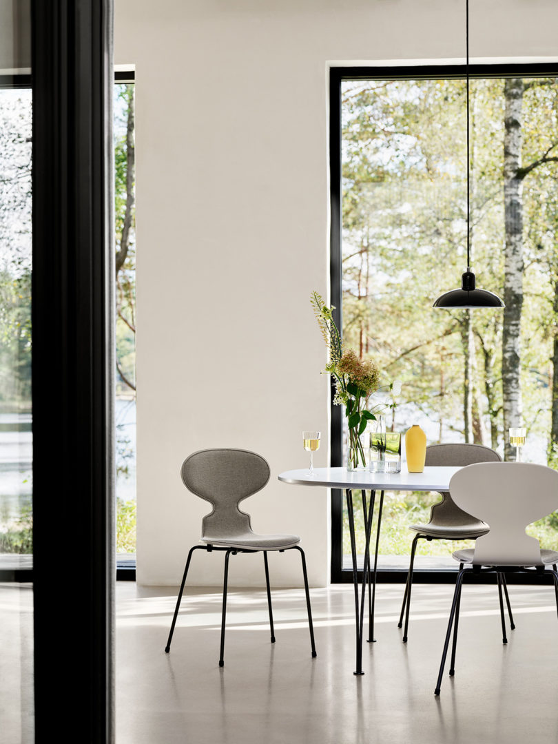 styled interior space with large windows, a table, and modern dining chairs