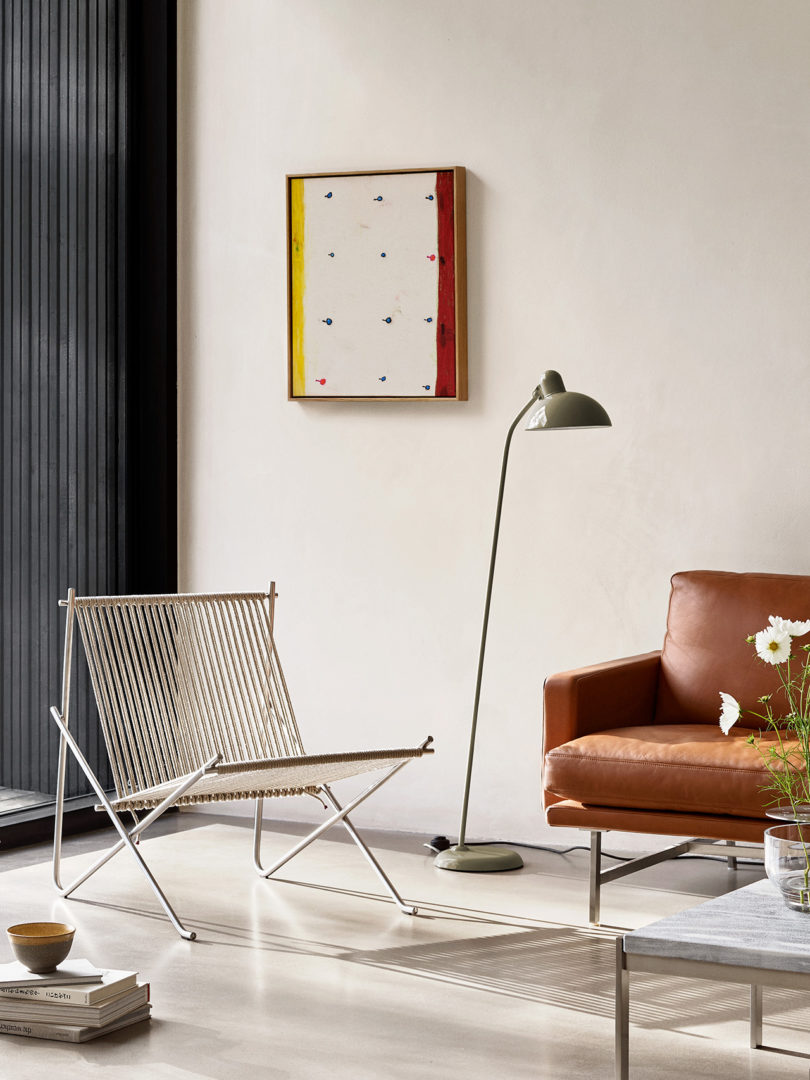 modern chair with rope back and seat, floor lamp, and brown sofa in a styled interior space