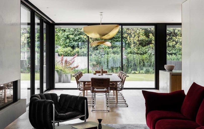 modern interior of living space and dining room with green yard beyond