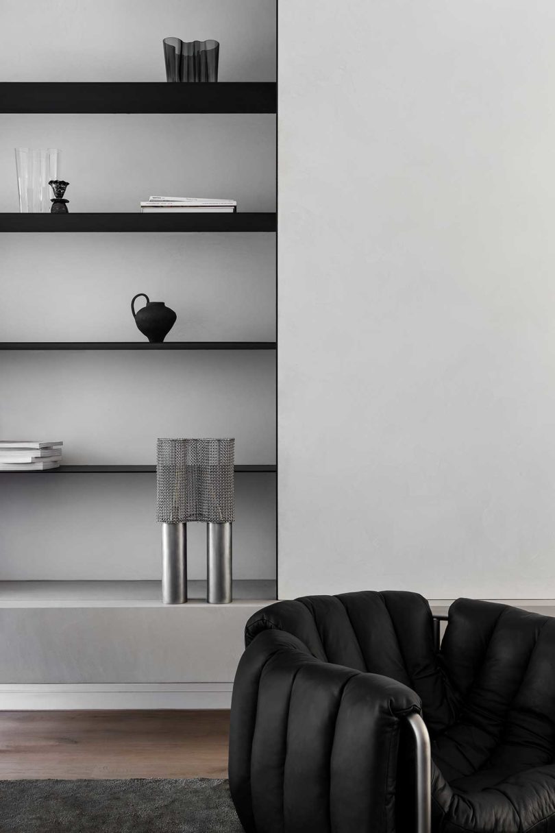closeup of modern interior with black chair and minimalist bookcasae