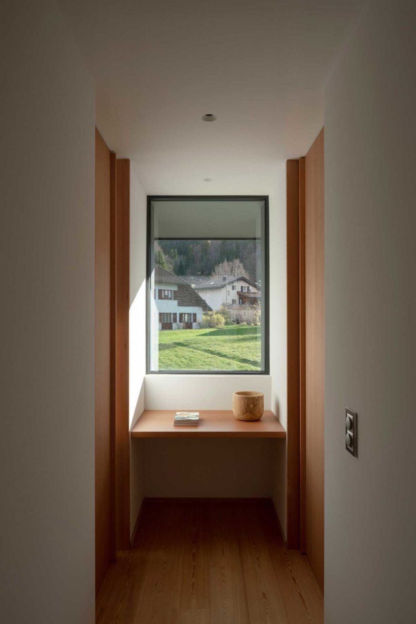 نمای راهرو انتهایی خانه مدرن که به بیرون از پنجره نگاه می کند