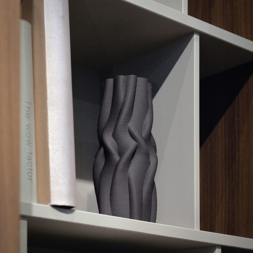 black 3D printed vase on a bookshelf