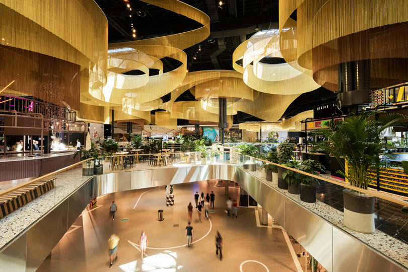 illuminated curvaceous chain link installations suspending above the first level of a shopping mall