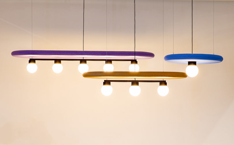 BuzziSurf acoustic pendant light shown in all two elongated oblong options and one round one, each outfitted with globe bulbs.