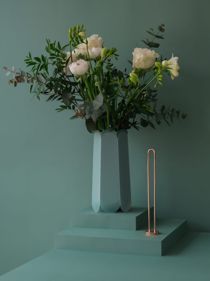 teal hexagonal-shaped vase with flowers