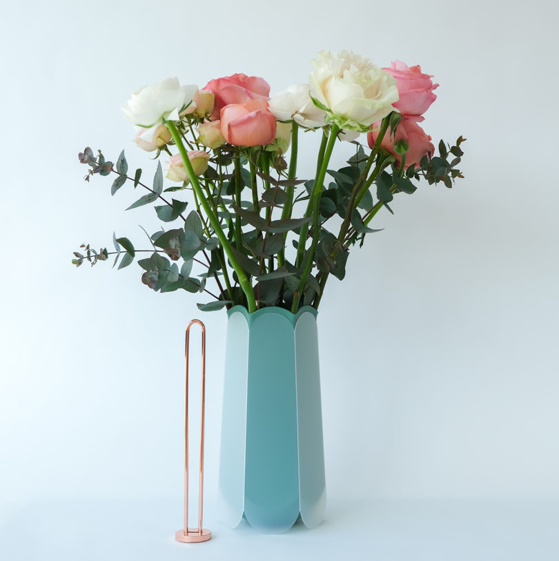 teal hexagonal-shaped vase with flowers