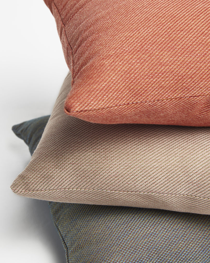 three brightly colored square throw pillows stacked