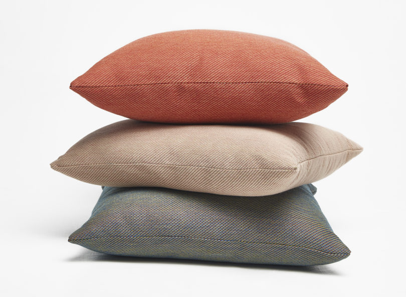 three brightly colored square throw pillows stacked