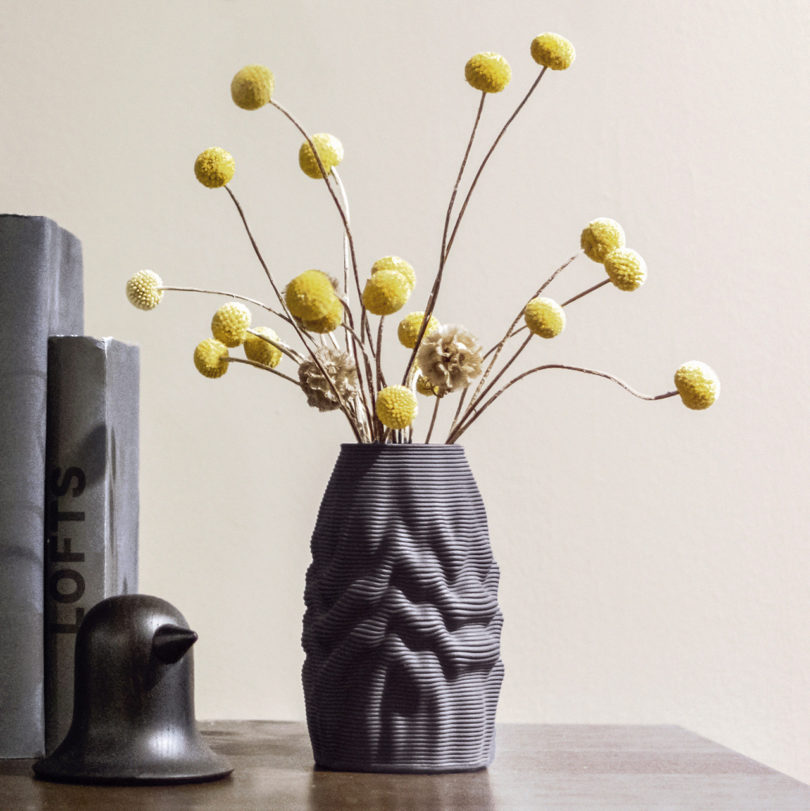 black 3D printed vase with yellow ball-shaped flowers