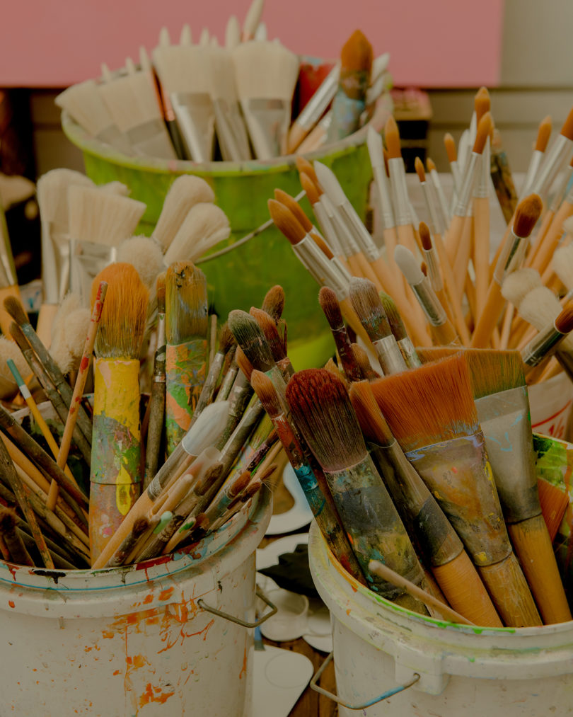 containers full of used paintbrushes