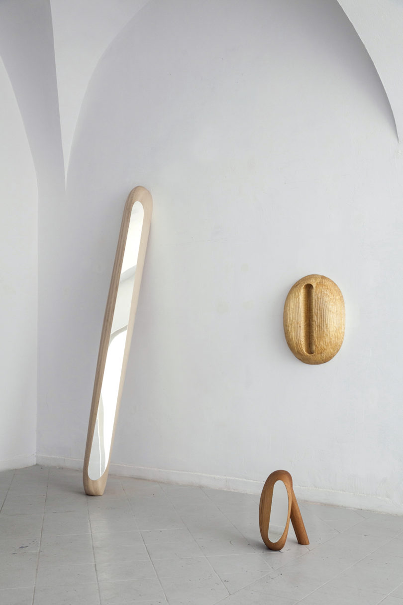 collection of three rudimentary wood and mirror objects in a gallery space
