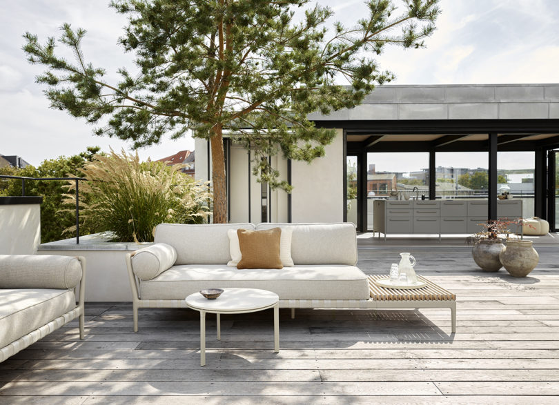 outdoor sofa with open end styled with a coffee table with a pavilion in the background