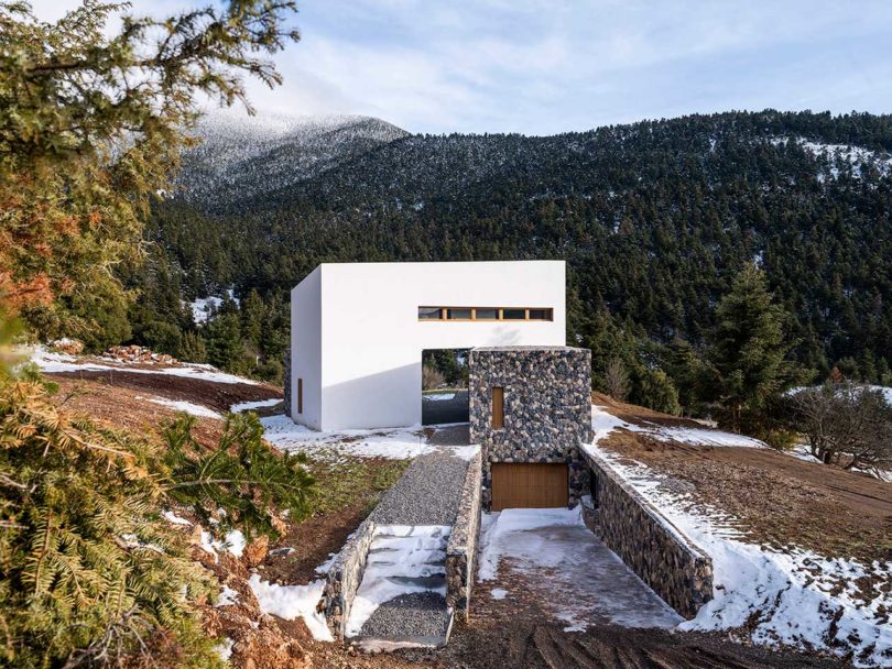 view of modern stone and white mountain house